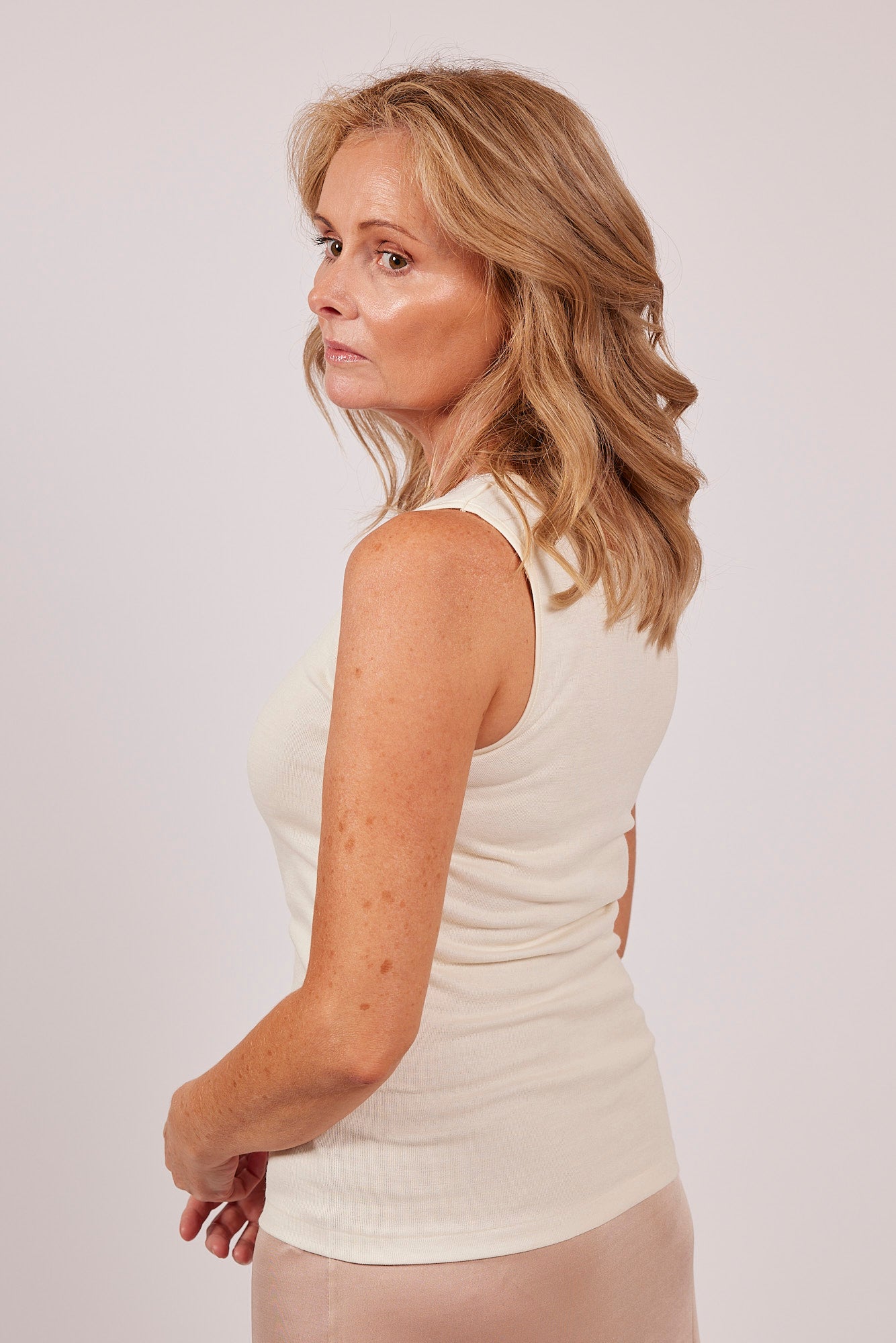Side profile of Wool & Cotton Doubleface Tank Top in ivory, styled with soft layering and feminine lace neckline.