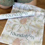 The Foundation Wash Bag shown with lingerie, featuring mesh fabric and Australian Botanical Print design.