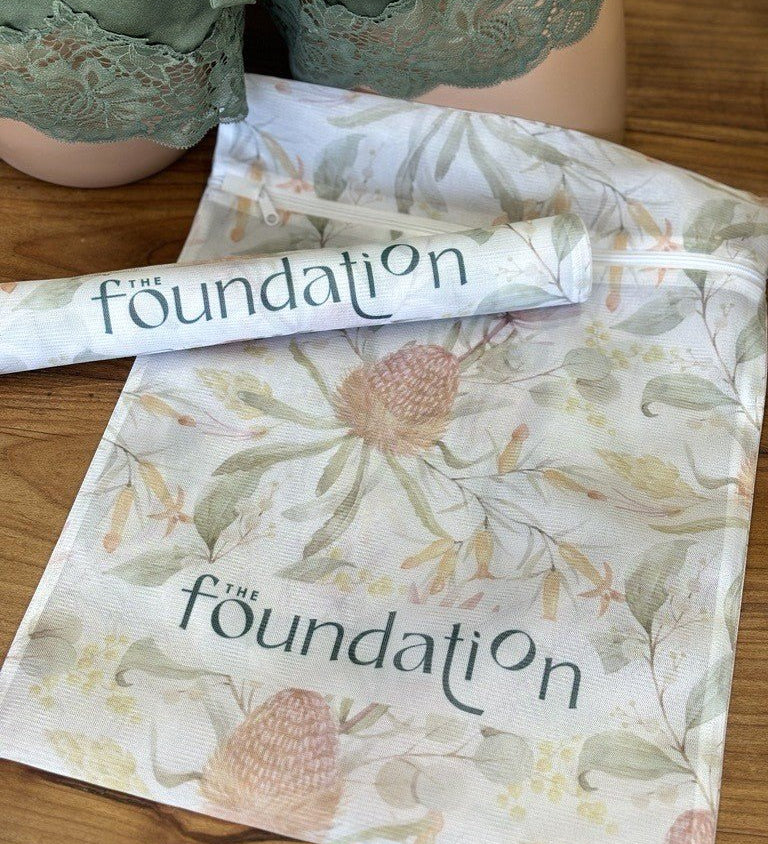 The Foundation Wash Bag shown with lingerie, featuring mesh fabric and Australian Botanical Print design.