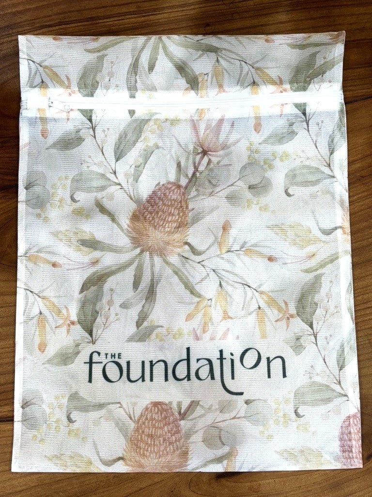 Flat lay of The Foundation Wash Bag with visible Foundation logo and floral print design.