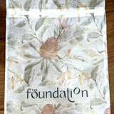 Flat lay of The Foundation Wash Bag with visible Foundation logo and floral print design.