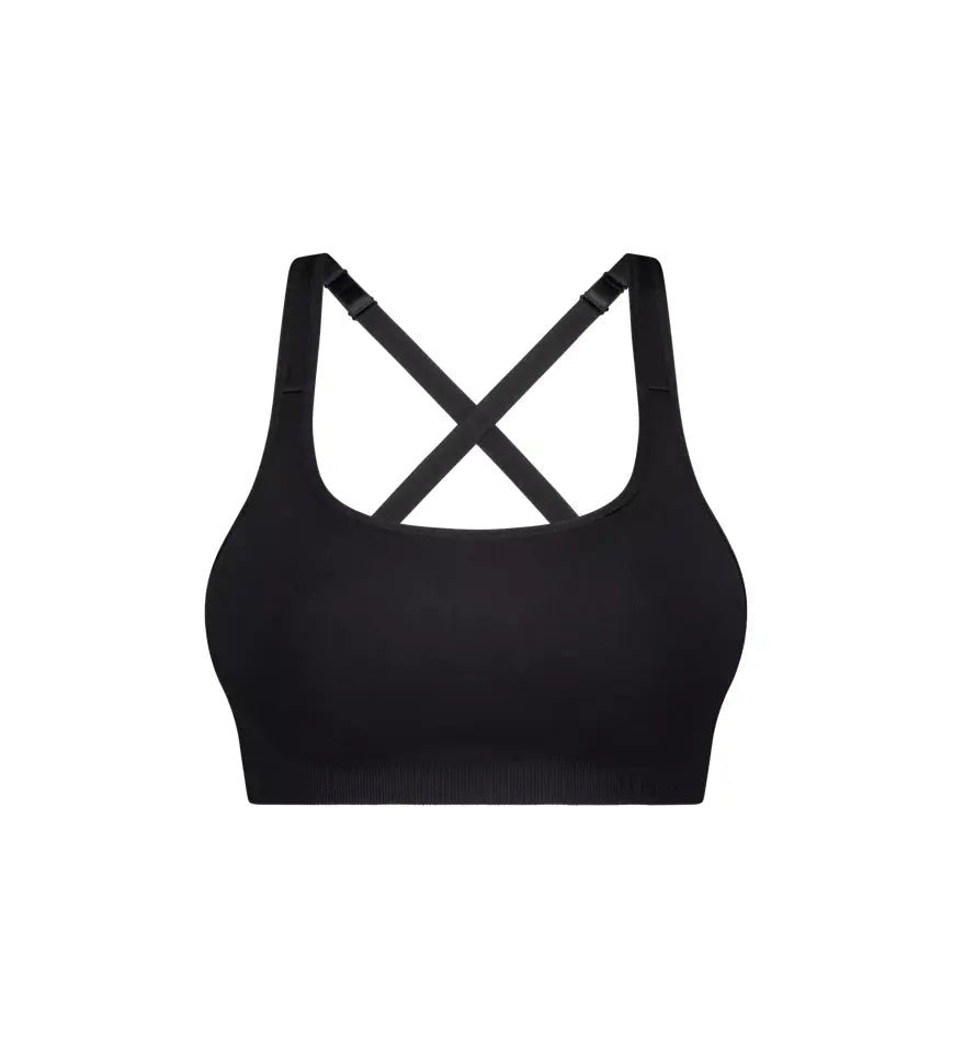 Flat lay of Triumph Triaction Ultra Seamfree Top Black, seamless crop sports bra, moisture-wicking fabric, cross-back design, Triumph Triaction range.