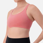 Triaction Ultra Seamfree Top in Salsa Pink by Triumph shown on model, wireless activewear crop with cross-back straps and double-layered support 