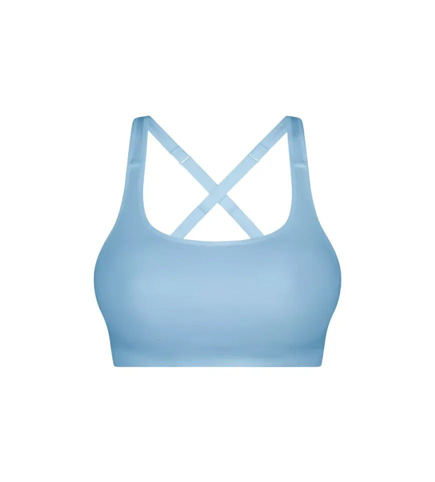 Flat lay of Triumph Triaction Ultra Seamfree Top Sky Blue, seamless sports bra, moisture-wicking activewear, cross-back detail, new limited edition colour.