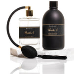Noir Laundry Gift Set with black scented wash bottle, atomiser, and fragrance spray, displayed with satin ribbon and packaging.
