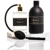 Noir Laundry Gift Set with black scented wash bottle, atomiser, and fragrance spray, displayed with satin ribbon and packaging.