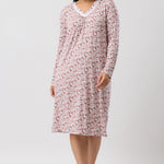 Woman wearing a pink floral nightshirt on a white background