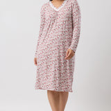 Woman wearing a pink floral nightshirt on a white background
