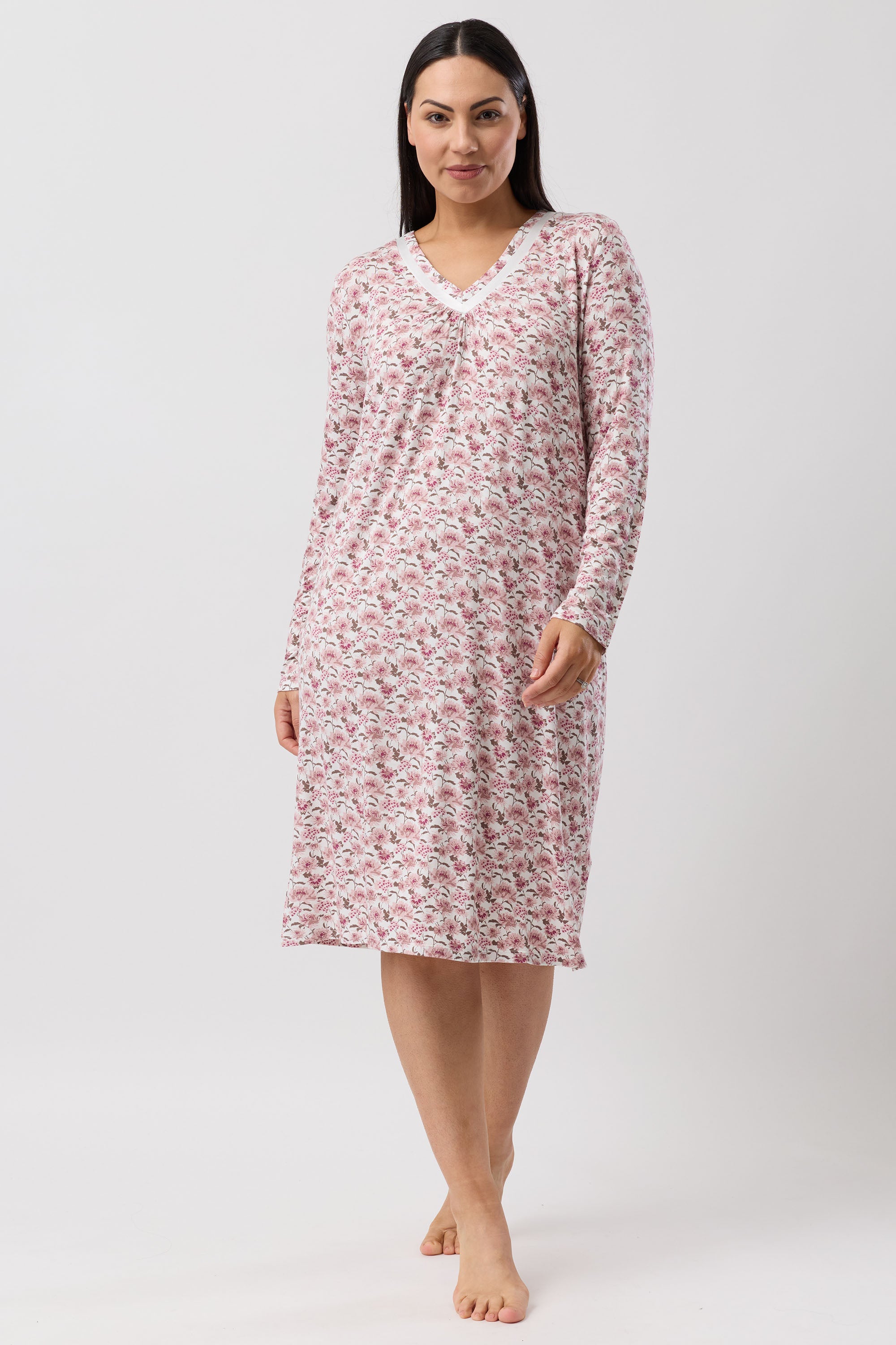 Woman wearing a pink floral nightshirt on a white background
