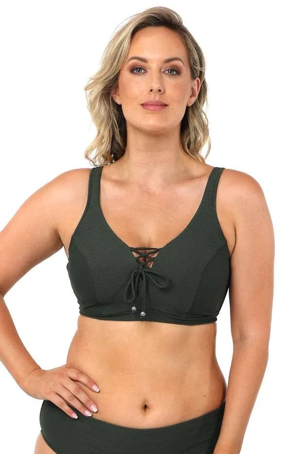 Model wearing Baku Rococco EFG Cup Bra Olive, an olive green underwire bra with lace-up front, convertible straps, and supportive full coverage, available at The Foundation.
