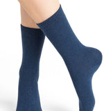 Bleuforêt Wool Cashmere Socks in Mid Admiral blue worn with bare legs, showing soft knit texture and mid-calf height, stocked at The Foundation.
