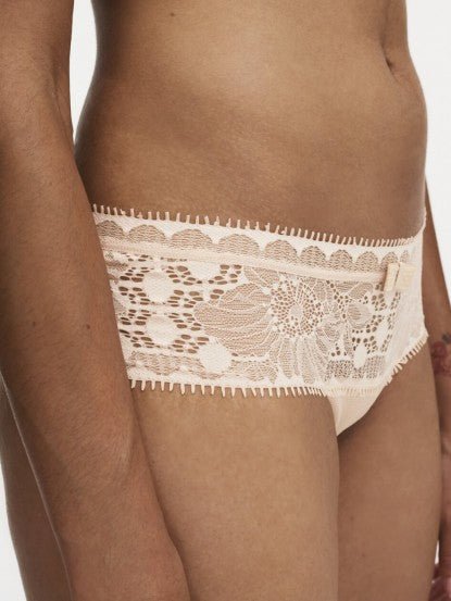 Model wearing Chantelle Day To Night Shorty Brief in Golden Beige, featuring delicate lace detailing, soft mesh lining, and a flattering hipster cut. side view