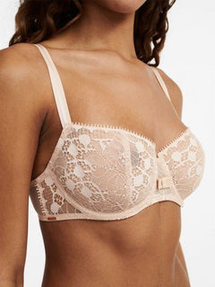 Model wearing Chantelle Day to Night Half Cup Bra in Golden Beige, featuring refined lace, demi cups, and soft adjustable straps for a lifted fit. close up