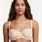 Model wearing Chantelle Day to Night Half Cup Bra in Golden Beige, featuring refined lace, demi cups, and soft adjustable straps for a lifted fit. front view