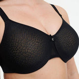 Model wearing Chantelle’s C Magnifique Moulded Bra in Black from The Foundation, featuring full-coverage cups and a smoothing mesh back band. close up