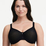 Model wearing Chantelle’s C Magnifique Moulded Bra in Black from The Foundation, featuring full-coverage cups and a smoothing mesh back band.