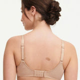 Model in Chantelle C Magnifique Moulded Bra in Nude from The Foundation, featuring seamless full cups, minimising support, and soft mesh band. back view