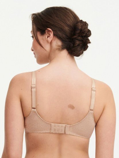 Model in Chantelle C Magnifique Moulded Bra in Nude from The Foundation, featuring seamless full cups, minimising support, and soft mesh band. back view