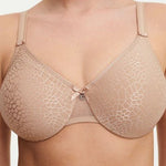 Model in Chantelle C Magnifique Moulded Bra in Nude from The Foundation, featuring seamless full cups, minimising support, and soft mesh band. close up view