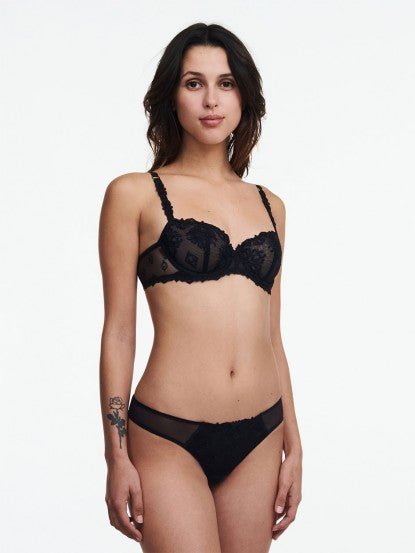 Model wears the full black lace set from The Foundation, featuring the Champs Elysees Half Cup Bra with matching brief.