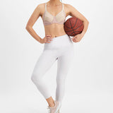 Woman in athletic pose wearing Electrify Mesh Underwire Sports Bra Soft Powder, showcasing active fit from The Foundation.