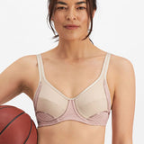 Woman wearing the Electrify Mesh Underwire Sports Bra in Soft Powder, front view with sports styling, available at The Foundation.
