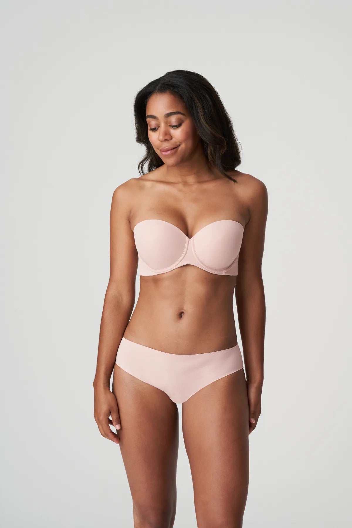 Model wearing Figuras Strapless Bra and brief set in Powder Rose – elegant and minimal full-body styling.