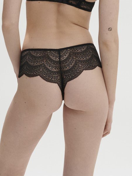 Model wearing Simone Pérèle Karma Shorty Brief in Black from The Foundation, mid-rise fit with scalloped lace and cheeky back design. back view