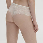 Model wearing Simone Pérèle Karma Shorty Brief in Natural from The Foundation, mid-rise lace design with cheeky back and scalloped edge detail. back view