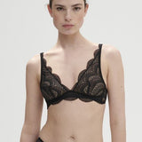 Model wearing Simone Pérèle Karma Wireless Triangle Bra in Black from The Foundation, with scalloped Italian lace and natural plunge neckline. front view