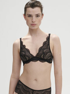 Model wearing Simone Pérèle Karma Wireless Triangle Bra in Black from The Foundation, with scalloped Italian lace and natural plunge neckline. front view