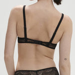 Model wearing Simone Pérèle Karma Wireless Triangle Bra in Black from The Foundation, with scalloped Italian lace and natural plunge neckline. back view