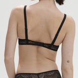 Model wearing Simone Pérèle Karma Wireless Triangle Bra in Black from The Foundation, with scalloped Italian lace and natural plunge neckline. back view