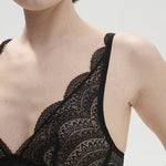 Model wearing Simone Pérèle Karma Wireless Triangle Bra in Black from The Foundation, with scalloped Italian lace and natural plunge neckline. close up