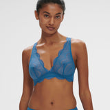 Model wearing the Simone Perele Karma Wireless Triangle Bra in vibrant Bleu Myosotis, featuring plunging neckline and scalloped lace detailing.