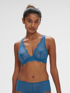 Model wearing the Simone Perele Karma Wireless Triangle Bra in vibrant Bleu Myosotis, featuring plunging neckline and scalloped lace detailing.