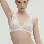Model wearing Simone Pérèle Karma Wireless Triangle Bra in Natural from The Foundation, with scalloped jacquard lace and convertible back straps. front view