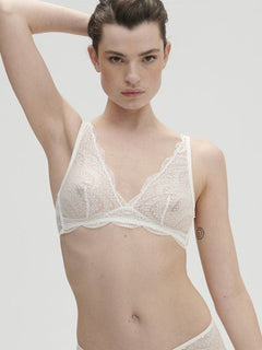 Model wearing Simone Pérèle Karma Wireless Triangle Bra in Natural from The Foundation, with scalloped jacquard lace and convertible back straps. front view