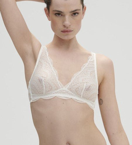 Model wearing Simone Pérèle Karma Wireless Triangle Bra in Natural from The Foundation, with scalloped jacquard lace and convertible back straps. front view
