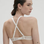 Model wearing Simone Pérèle Karma Wireless Triangle Bra in Natural from The Foundation, with scalloped jacquard lace and convertible back straps. back view