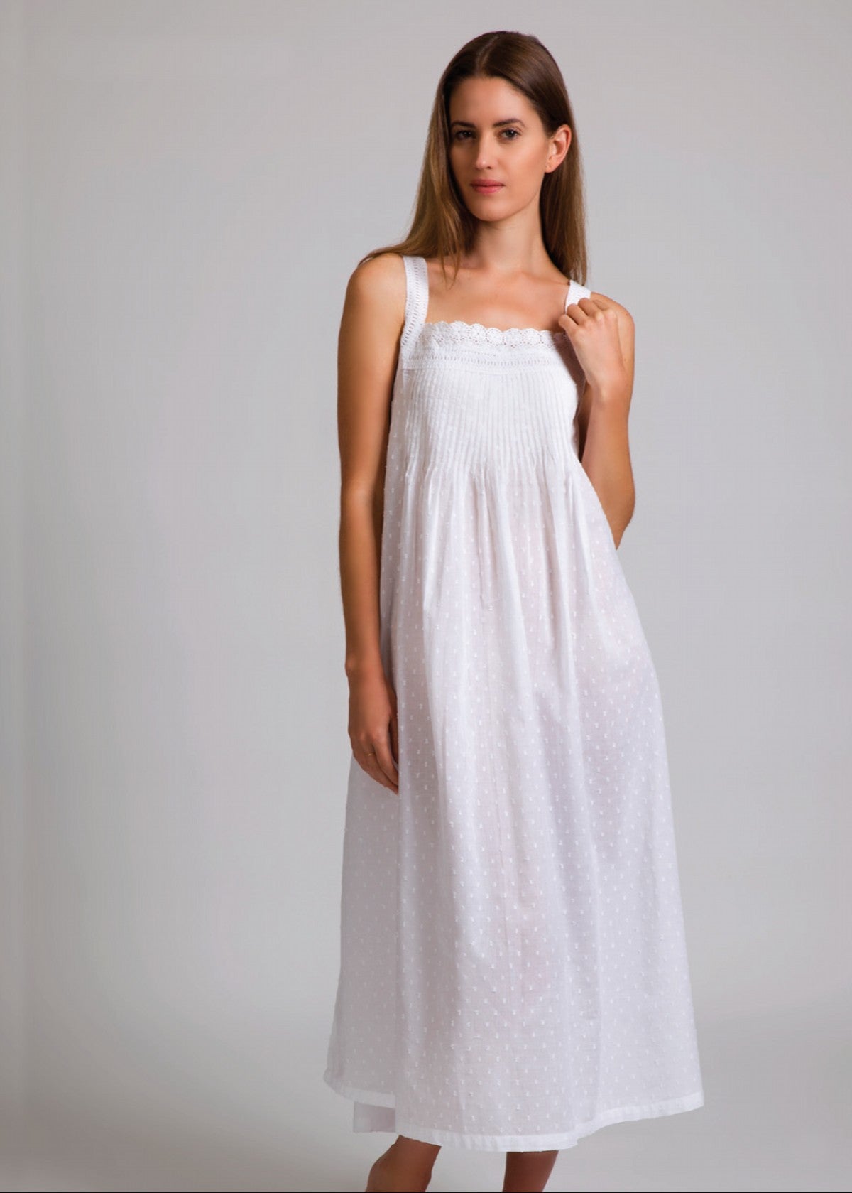 Model wearing Hailspot Sleeveless Pintuck Nightie in white, featuring hail spot cotton texture, pintuck detail, and lace-trimmed square neckline.