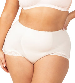 Plus-size model wearing the Something Else Tum-E-Lace Full Brief in Fresh Powder by Triumph, showing high-waisted tummy control fit.