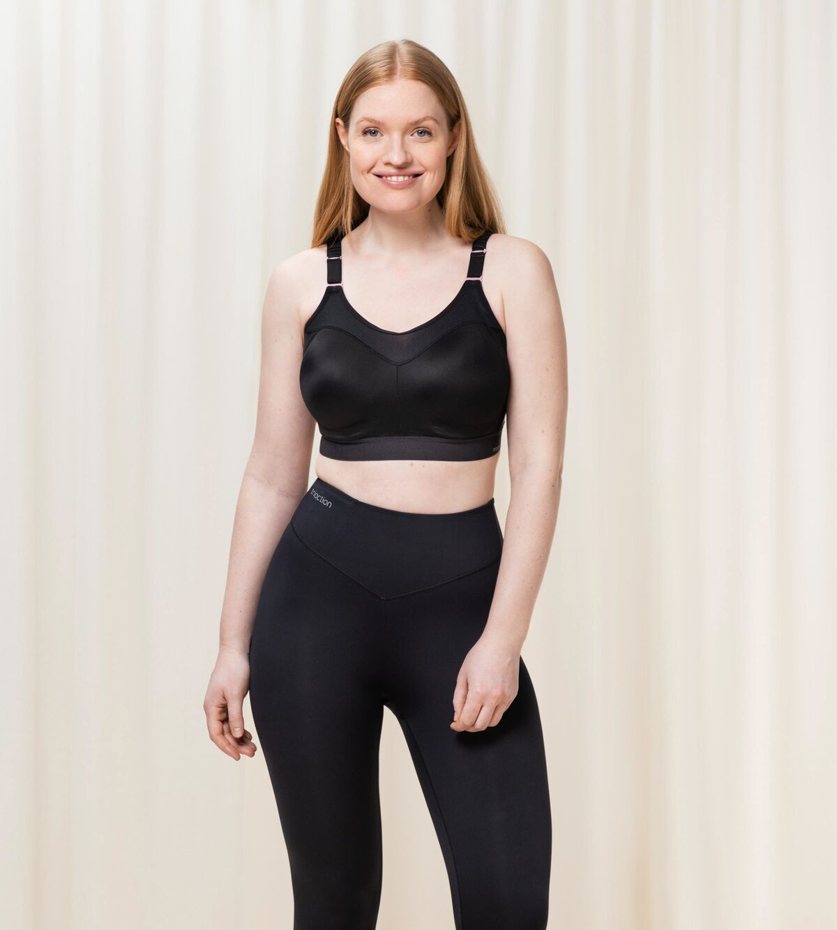 Model standing in full Triaction Control Lite Black sports bra and leggings set, showing active, supportive style