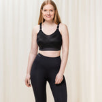 Model standing in full Triaction Control Lite Black sports bra and leggings set, showing active, supportive style