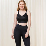Model standing in full Triaction Control Lite Black sports bra and leggings set, showing active, supportive style