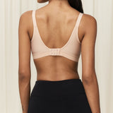 Back view of the Triaction Wellness bra Neutral Beige, featuring mesh-lined cups and adjustable straps.