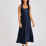 Model wearing navy blue silk long nightie with wide straps and flattering scoop neckline.