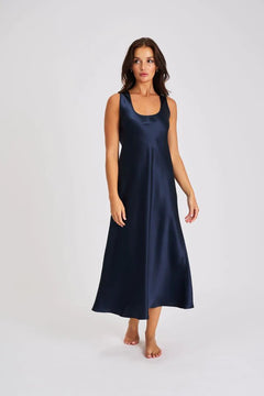 Model wearing navy blue silk long nightie with wide straps and flattering scoop neckline.