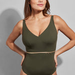 Model wearing the Empreinte Cosmic V-Neck One Piece swimsuit in Lichen green with gold strap detail and flattering neckline.
