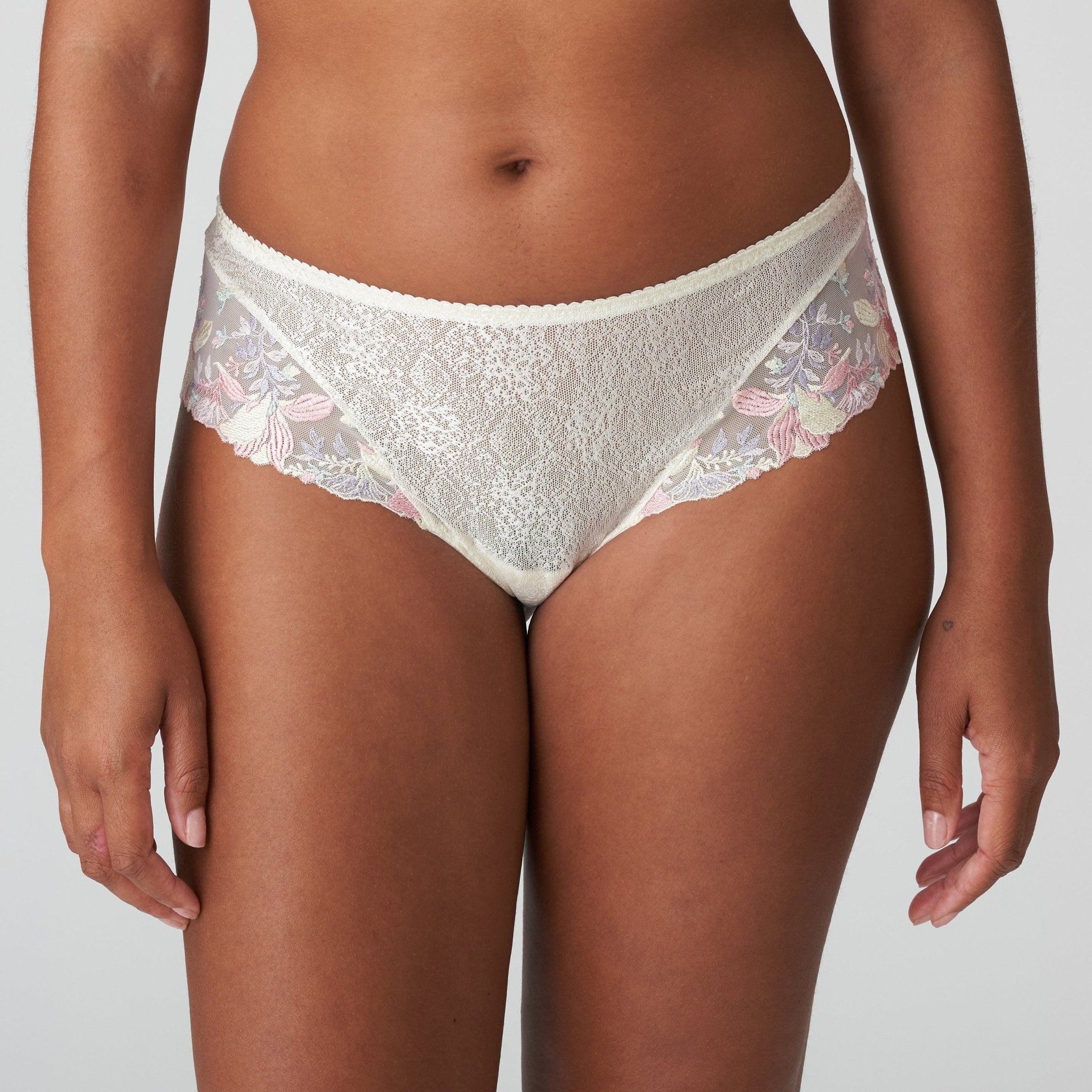 Front view of Prima Donna Mohala Luxury Thong Brief Vintage Natural on model showing soft pastel floral embroidery and lace fabric.